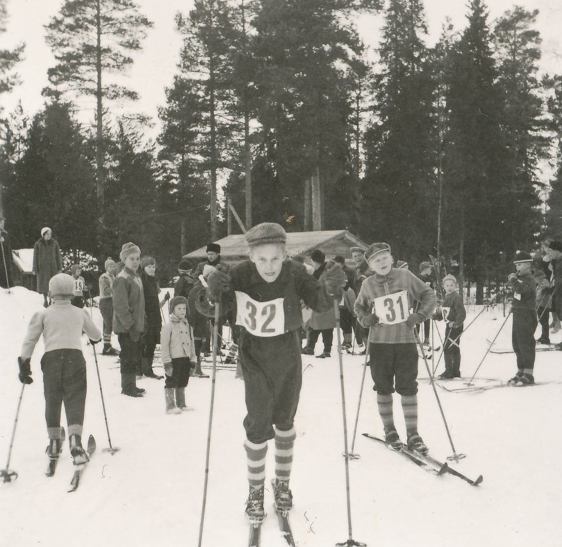 Poikia lähdössä hiihtokilpailuun numerolaput rinnassa 1950-luvun Leppiniemessä